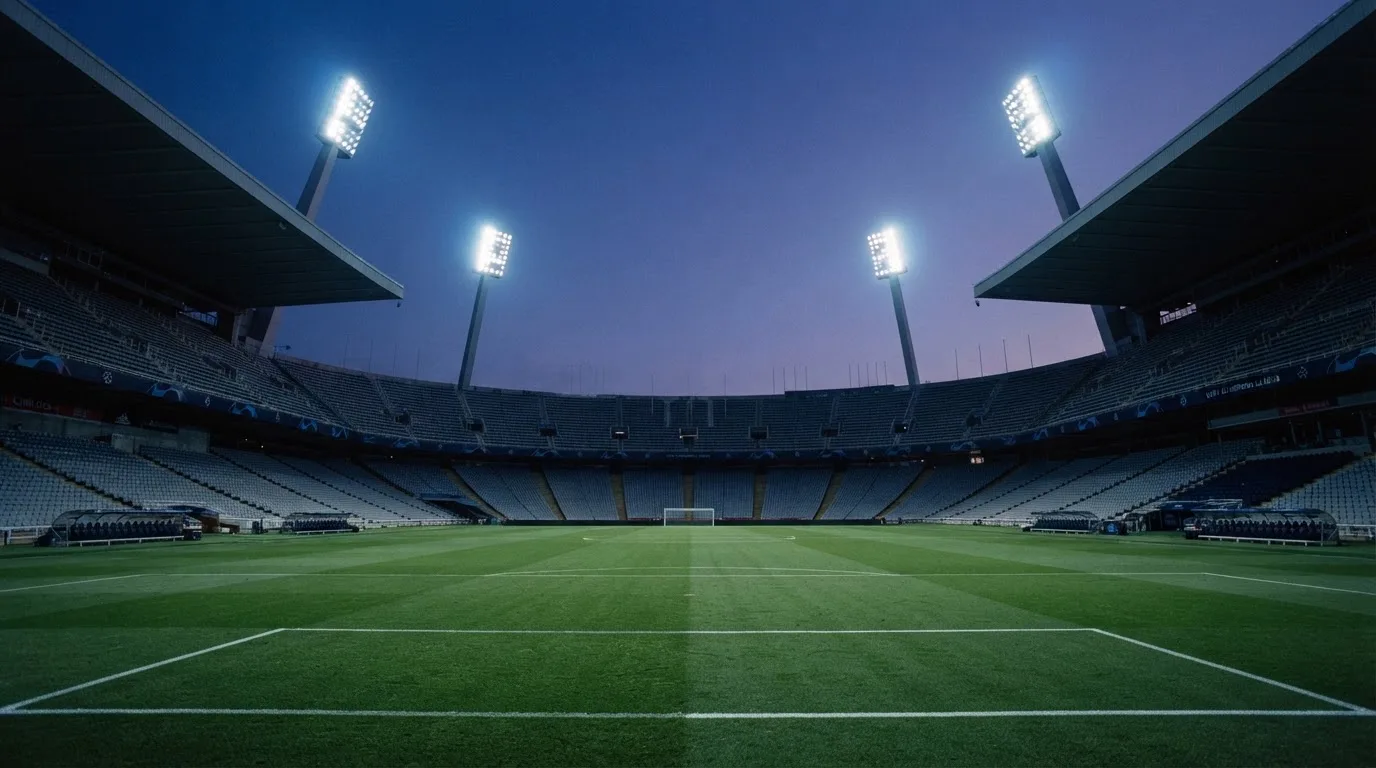 Een leeg voetbalstadion met lichtmasten bij schemering
